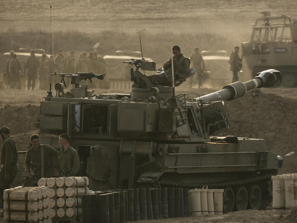 Israeli soldiers sit on an artillery unit near the Israeli border with the Gaza Strip, in Netivot, Israel, Oct. 22.