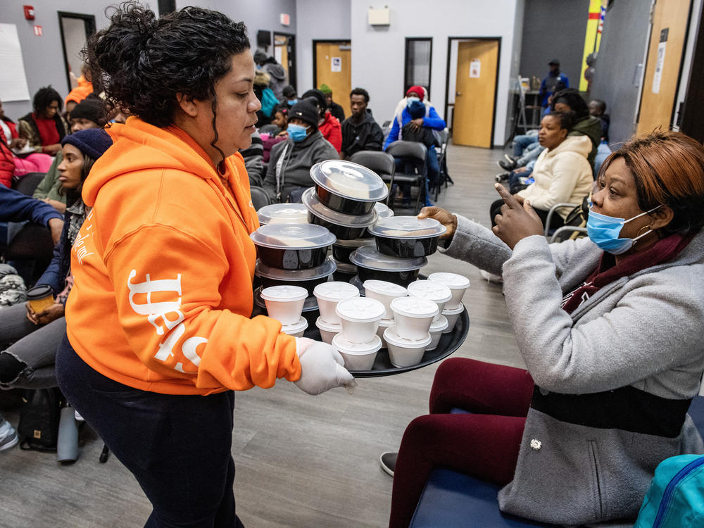 Brenda Romero distributes food to migrants at the La Colaborativa day shelter in Chelsea, Mass., on Feb. 22. The shelter provides services to migrants,