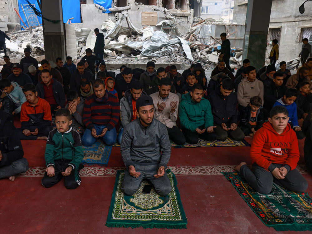 Palestinians perform Friday noon prayers at the Al-Hoda mosque, destroyed in Israeli bombardment in mid-February, after worshipers cleared rubble to make space for praying, in Rafah, the Gaza Strip, Friday.