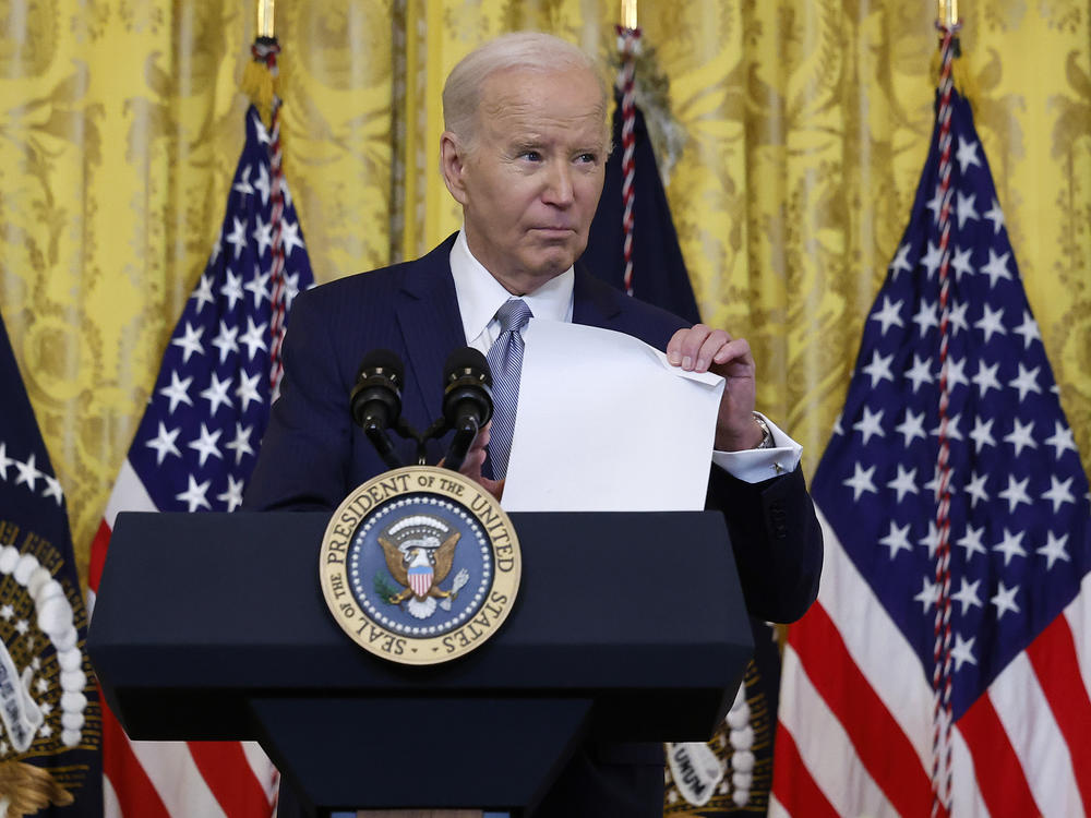 President Biden holds up a fact sheet about the failed Senate deal on border security while speaking to governors at the White House on Feb. 23.