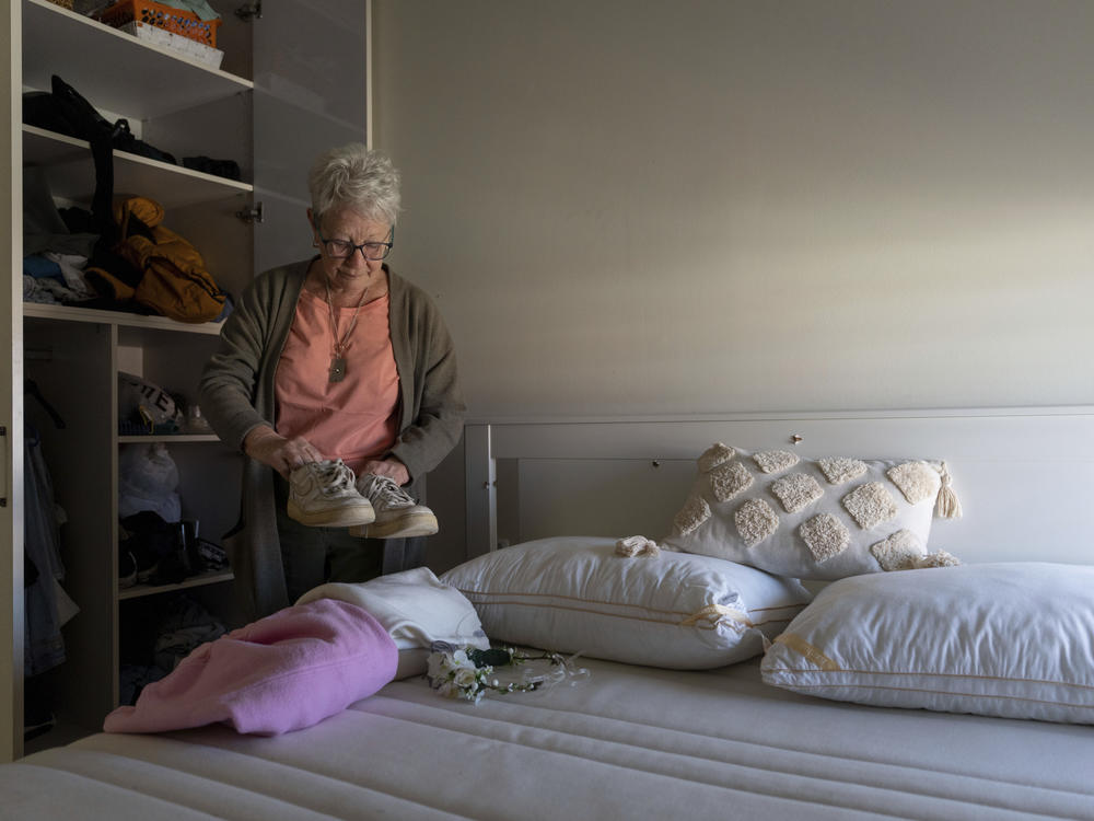 Gillian Brisley arranges clothes in her relatives' home in Kibbutz Be'eri, in southern Israel, on Wednesday, Feb. 21. Gillian's daughter and two granddaughters were killed in Hamas' Oct. 7 attack, and their son-in-law was taken captive.