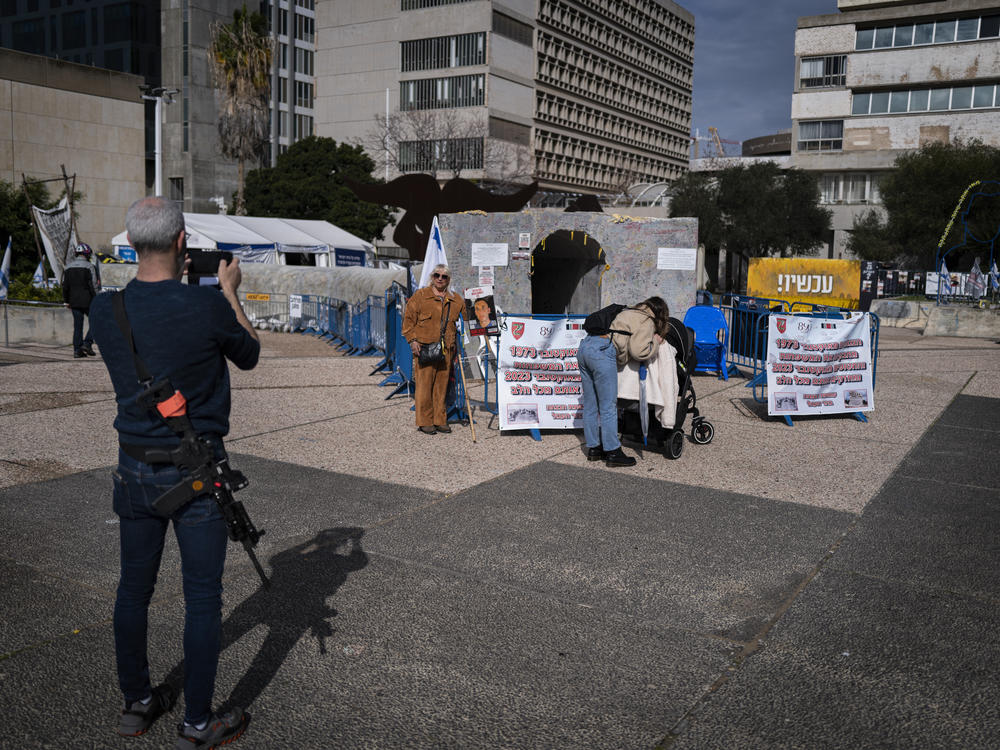 A couple, one armed, pose for a photo in front of a mock Hamas tunnel in what has become known as Hostage Square in Tel Aviv, Israel, on Monday, Feb. 19. This is a round-the-clock encampment for those seeking the return of Israelis held by Hamas in Gaza.