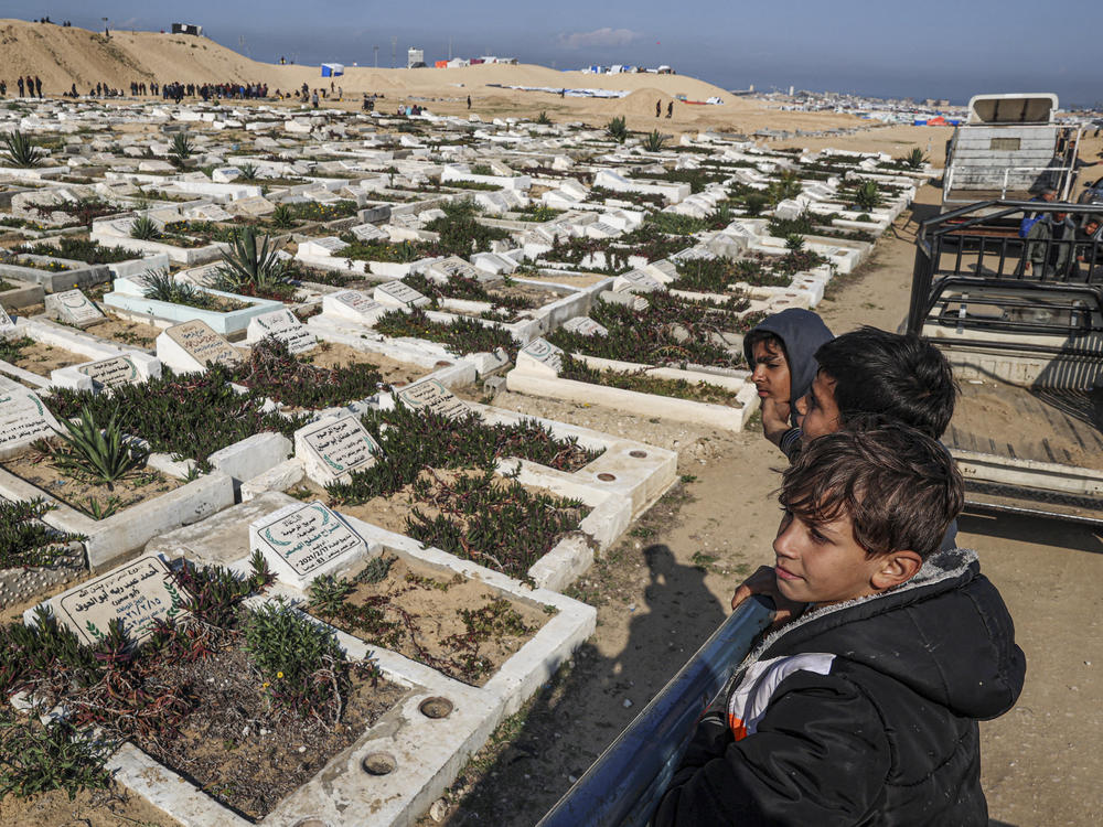 Palestinian children look at a cemetery in Rafah on Wednesday, Feb. 21.