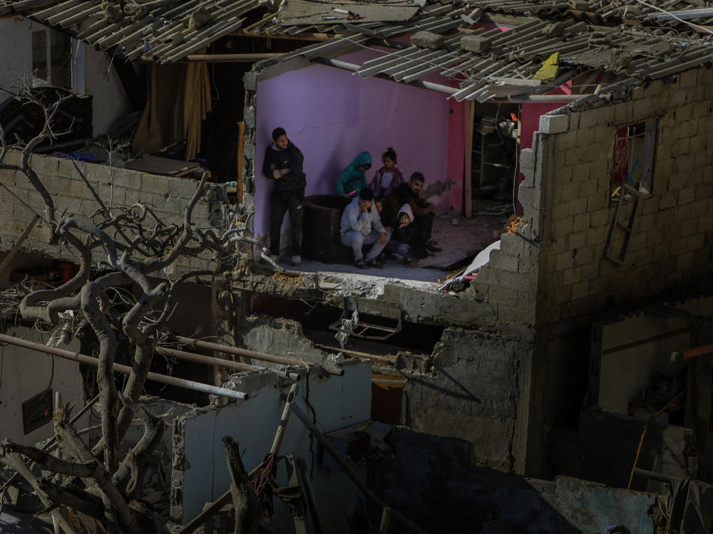 Palestinians stand in damaged structures after an overnight Israeli bombardment in Rafah, in southern Gaza, on Thursday, Feb. 22.