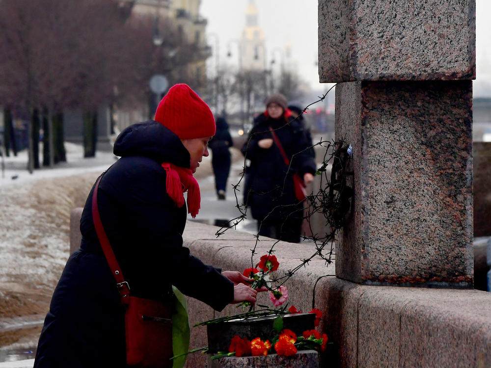 A woman lays flowers at the Memorial to Victims of Political Repression to pay respect to Alexei Navalny in Saint Petersburg on Saturday.