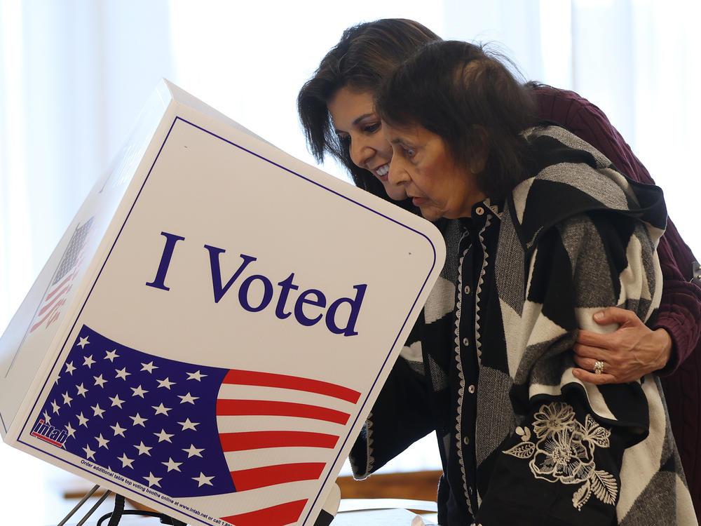 Republican presidential candidate former U.N. Ambassador Nikki Haley (L) helps her mother Raj Kaur Randhawa (R) cast her ballot in the South Carolina Republican primary on Saturday in Kiawah Island, S.C.