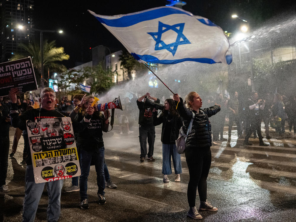 Israeli police use water cannons to disperse demonstrators blocking a road in Tel Aviv on Saturday, Feb. 24, as they protest Israeli Prime Minister Benjamin Netanyahu's government and demand the release of hostages still being held in Gaza.