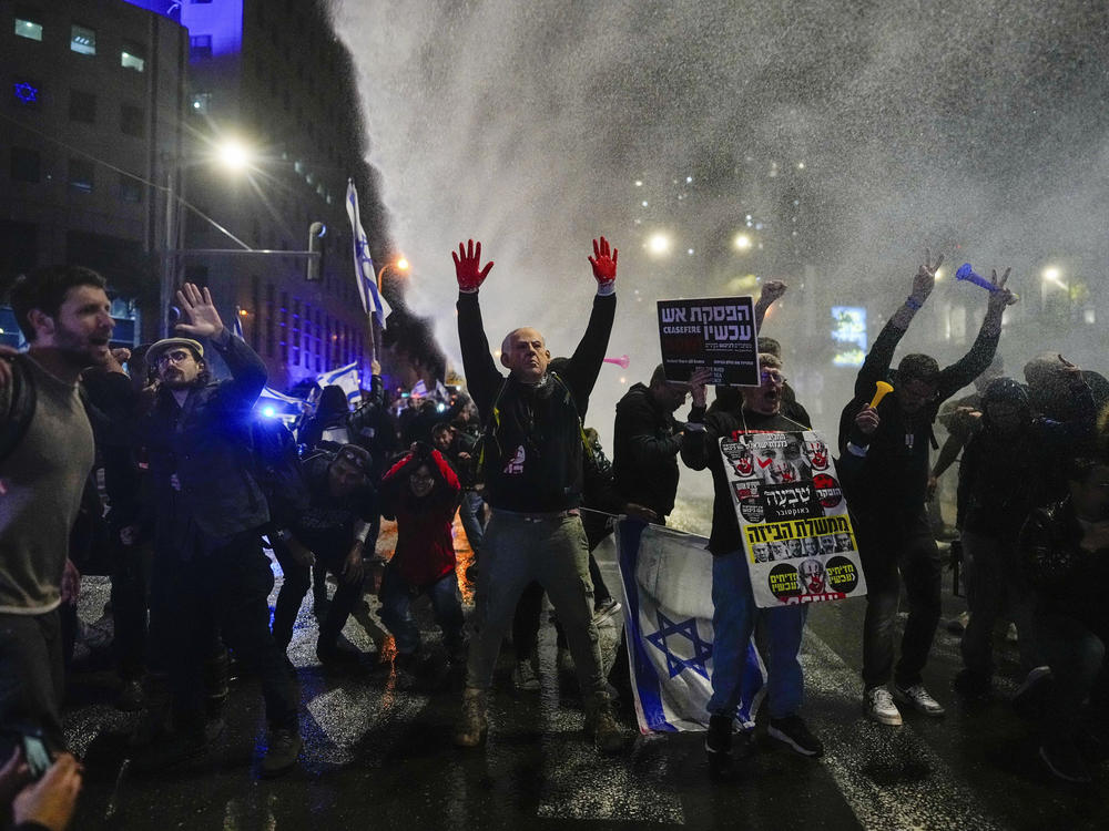 Police in Tel Aviv, Israel, use water cannons to disperse demonstrators during a protest against Israeli Prime Minister Benjamin Netanyahu's government, and calling for the release of hostages held in the Gaza Strip by Hamas, on Saturday.
