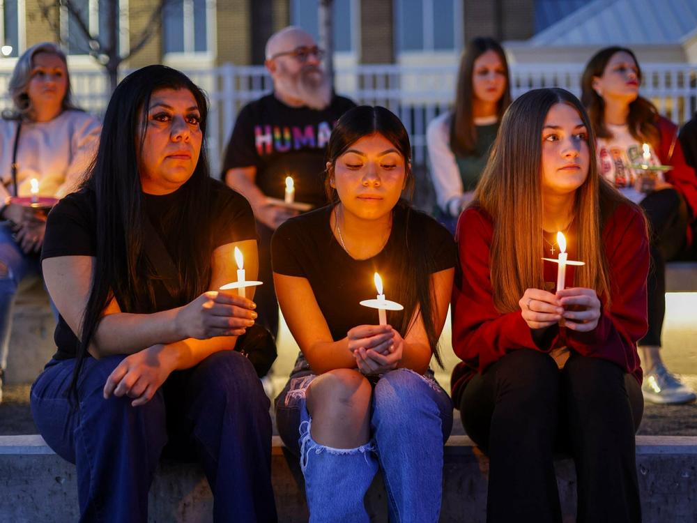 Patricia Saquilo, left, and her daughter Allyson Andrade, 13, and Hadley Mayopulos, 13, participate in a community candlelight vigil for Nex Benedict on Sunday, Feb. 25, 2024, in Owasso, Okla.