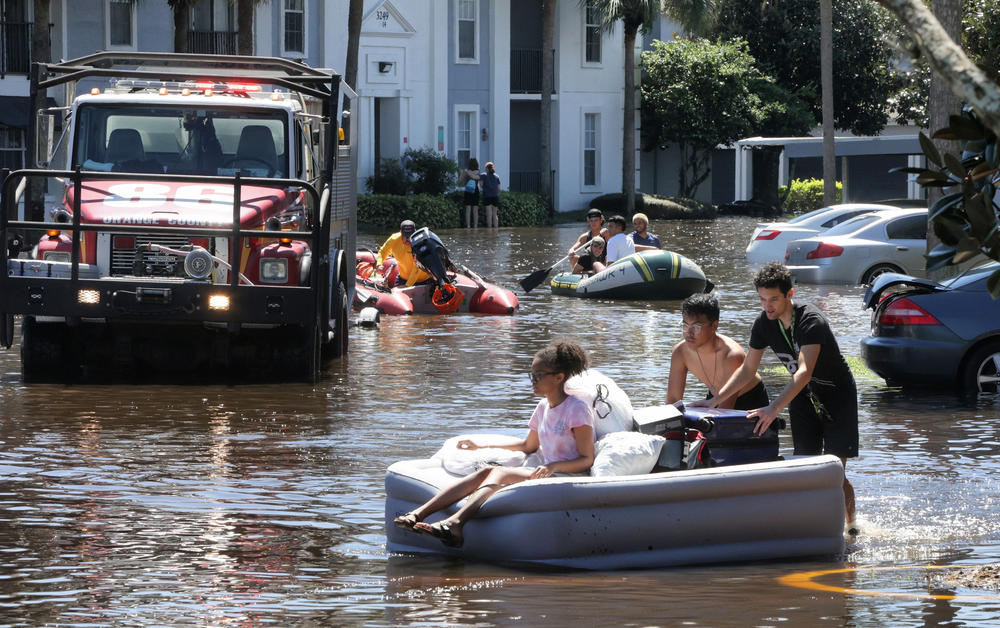 Residents escape from flooded homes in September 2022, after heavy rains from Hurricane Ian flooded an apartment complex near the University of Central Florida.