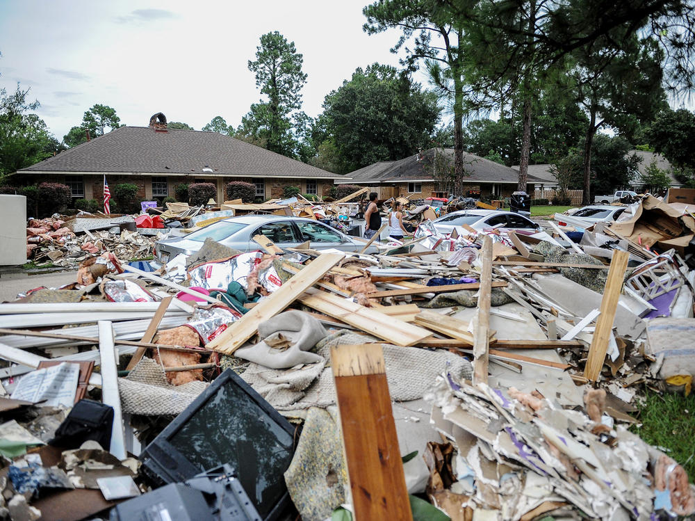 Climate-driven disasters are getting more frequent. They can be particularly destabilizing for college-age people who are in socially and financially formative years. Here, debris piled outside a home after a massive flood in Baton Rouge, La., in 2016.