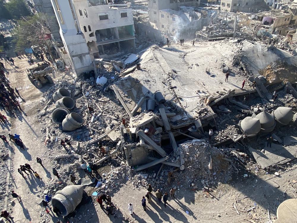 People survey what remains of buildings in Rafah that were hit by Israeli bombardments on Sunday, Feb. 25.