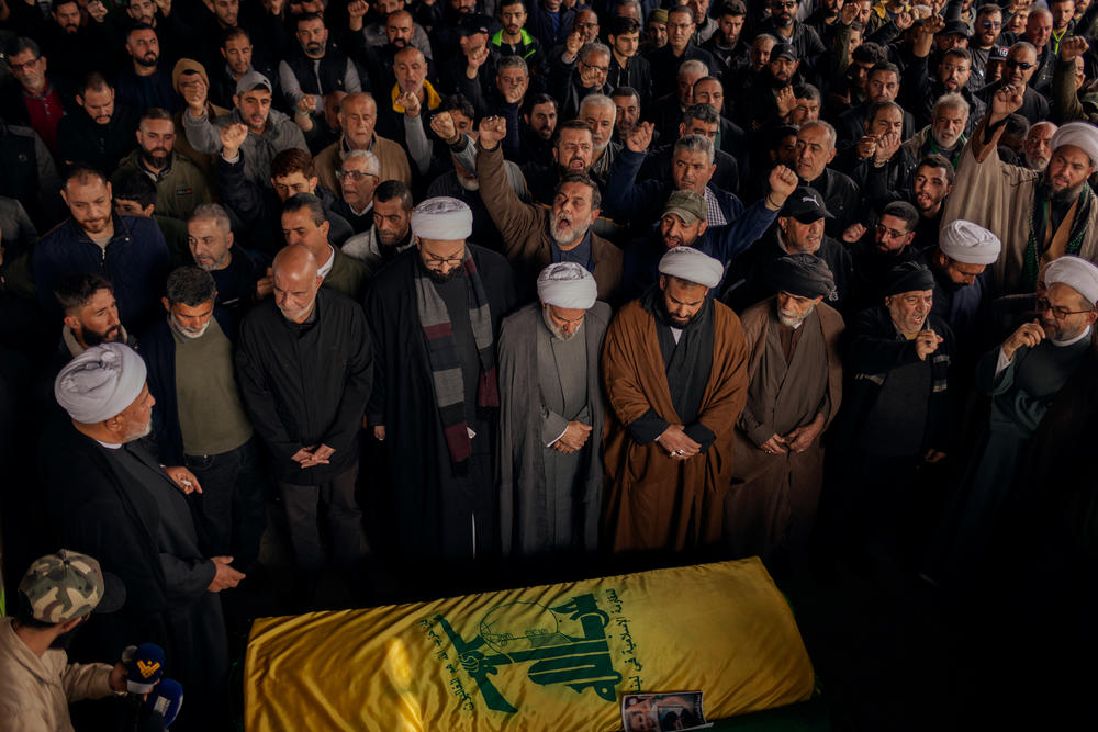 Muslim clerics, relatives and friends mourn the death of Khadija Salman in Majdal Zoun, on Feb. 22. A Hezbollah flag covers the coffin, in a region of Lebanon where support for the militia is strong.