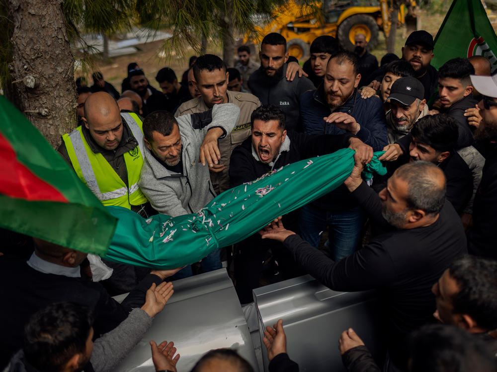 Relatives of Amal Hassan al-Durr, a 5-year-old girl, lay her body to rest at the cemetery in Majdal Zoun, southern Lebanon, on Feb. 22. She lost her life during an Israeli attack. <a href=