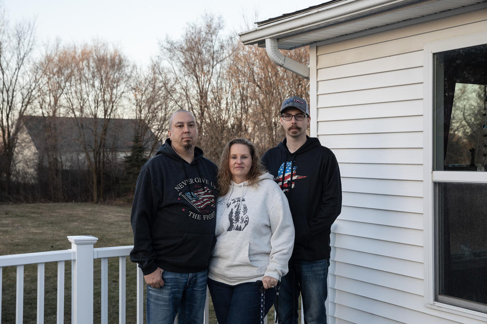 Matt Zissler, Shelly Zissler and her son, Matt Vaughn, who all work for General Motors' Flint Assembly plant, pose for a portrait outside their home in Flint, Mich., on Saturday.