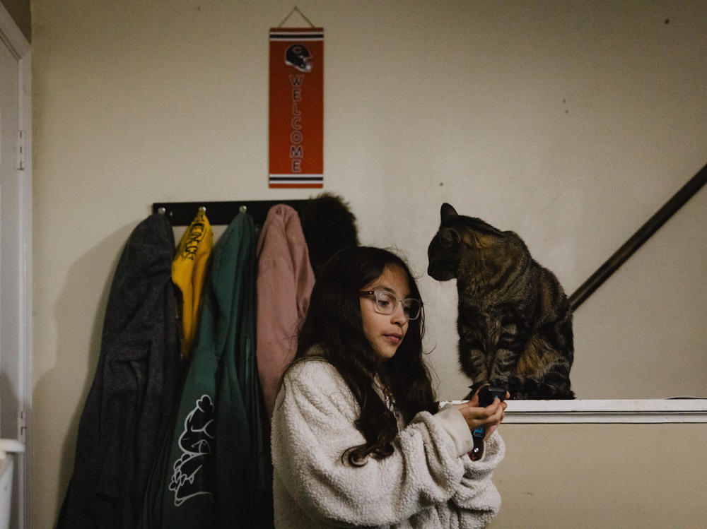 Calliope Santiago with her cat, Pixel. Among other things, her dad has used extra cash payments to pay for her ballet classes and family trips.