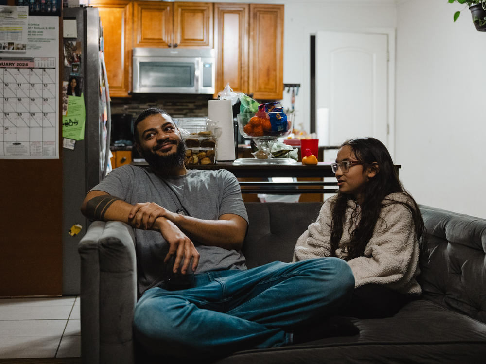 Christopher Santiago, 38, hangs out at home in Alsip, Ill., with one of his three children, 9-year-old Calliope. He says Cook County's basic income program has let him provide more for his kids.