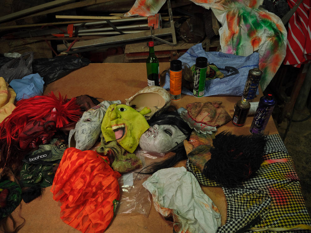 Shop-bought masks and cans of spray paint — normally used to tag sheep — lie ready to be used inside the Okalolies' clandestine changing room: a small sawmill. The Okalolies use a mix of shop-bought items, old dresses and coats to put together their outfits. The goals are to disguise themselves as scarily as possible and to remain anonymous throughout the day.