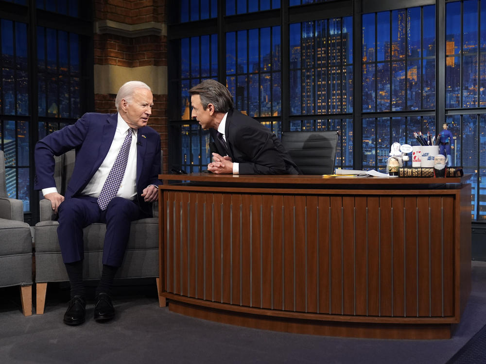 President Biden talks with Seth Meyers during a taping of NBC's <em>Late Night with Seth Meyers</em> on Feb. 26 in New York.