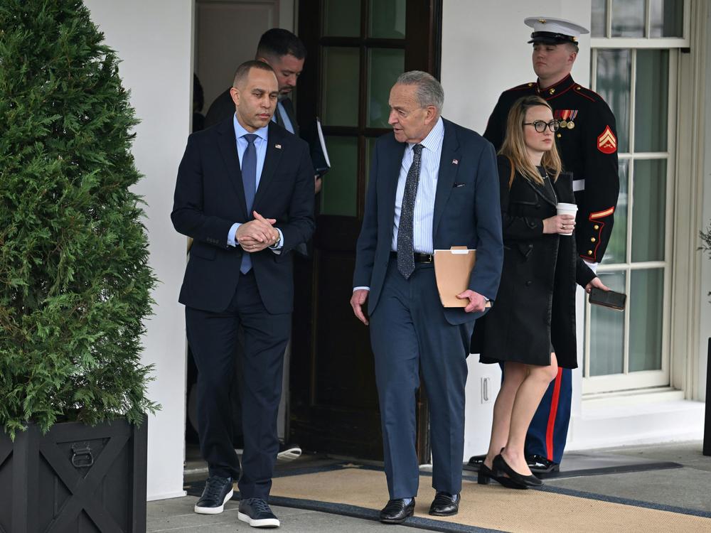 House Minority Leader Hakeem Jeffries and Senate Majority Leader Chuck Schumer leave the West Wing to speak with reporters after a meeting with President Biden and Republican congressional leaders.