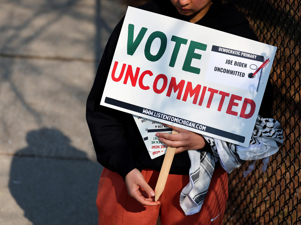 A Democratic voter uncommitted to President Biden rallies outside of a polling location at Maples Elementary School on Feb. 27 in Dearborn, Mich.