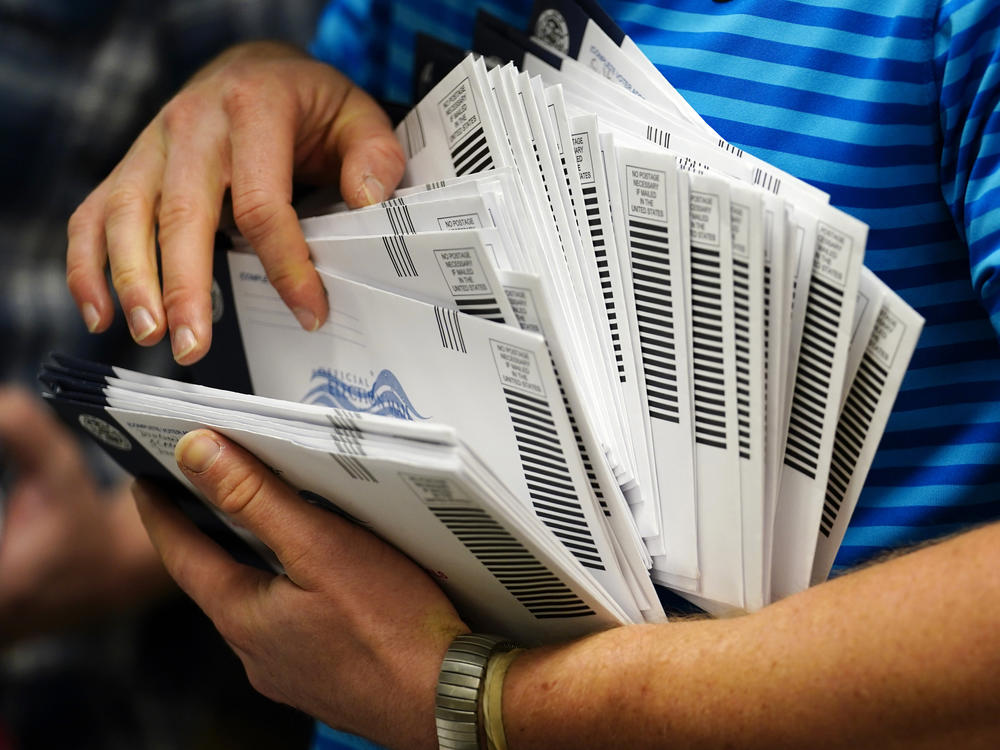 A local election official organizes mail-in ballots to be sorted for the 2020 general election in West Chester, Pa.