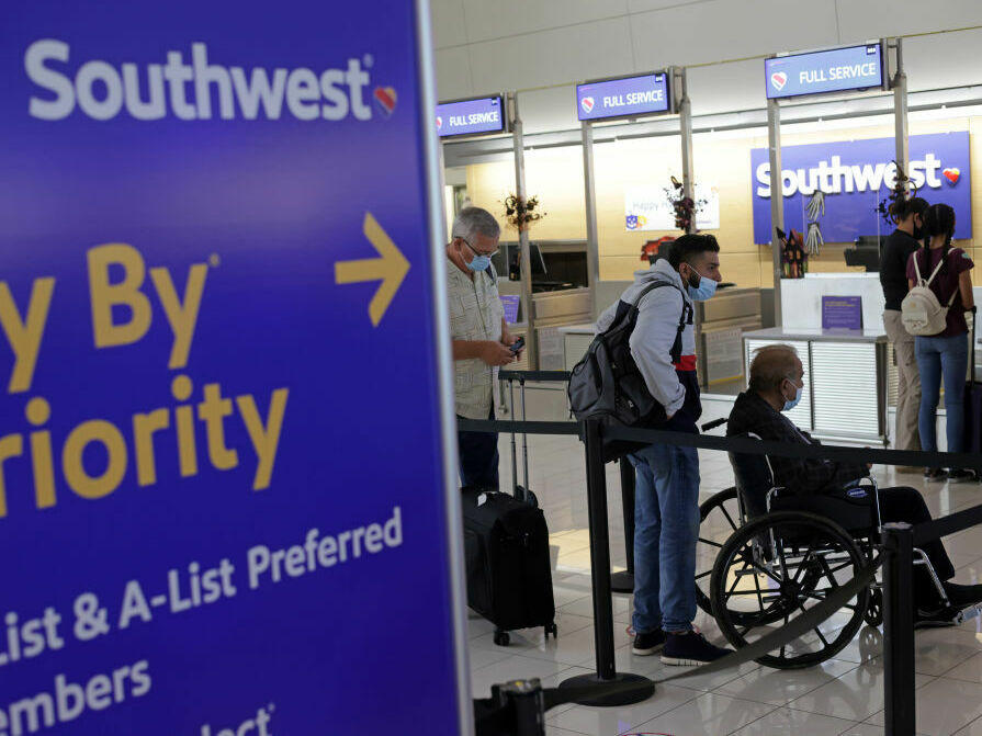 Passengers wait in line at Ronald Reagan Washington National Airport in 2021 in Virginia.