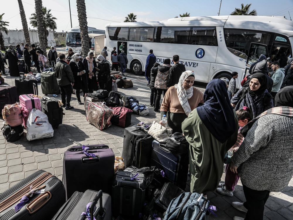 Palestinians holding foreign passports collect their luggage as they prepare to cross to Egypt from the Gaza Strip through the Rafah border crossing on Feb. 6.