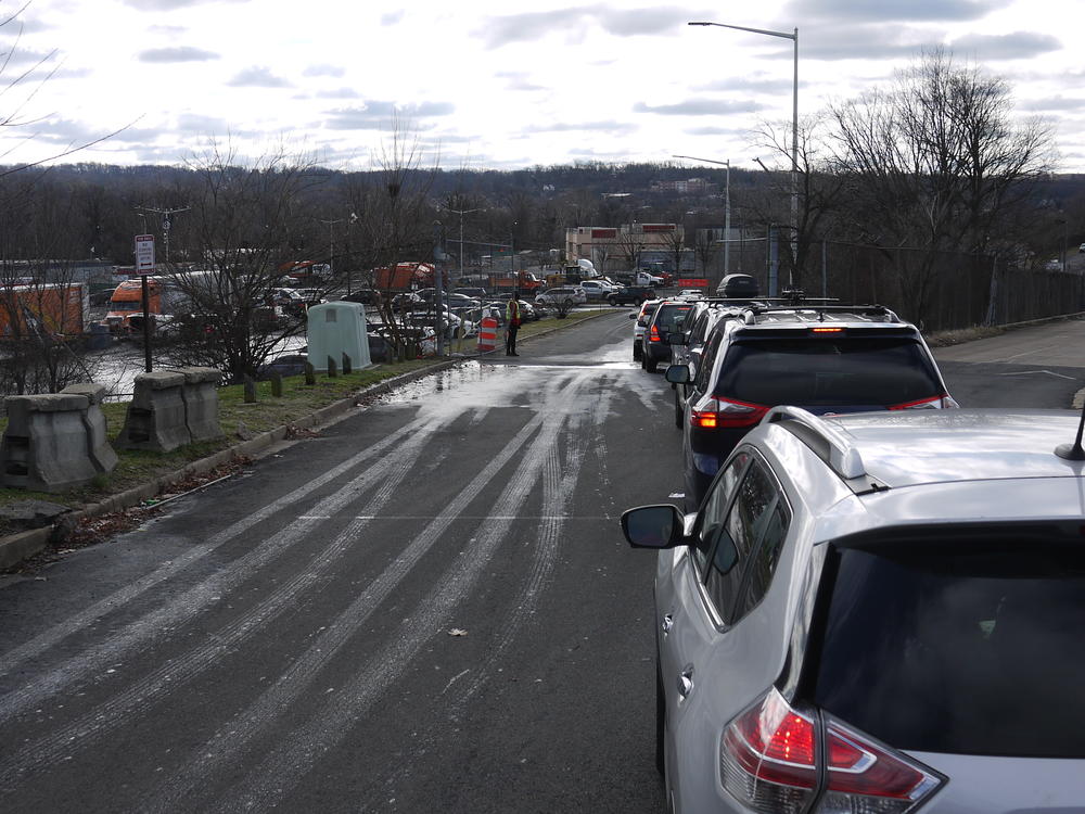 A line of cars stretches down into a parking lot where semitrailers are waiting to unload Girl Scout Cookies in Washington, D.C.