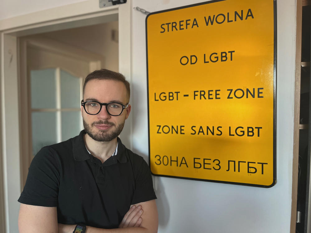 Civil rights activist Bart Staszewski stands beside a sign he made as a performance art project to raise awareness about the dozens of cities in eastern Poland that had declared themselves 