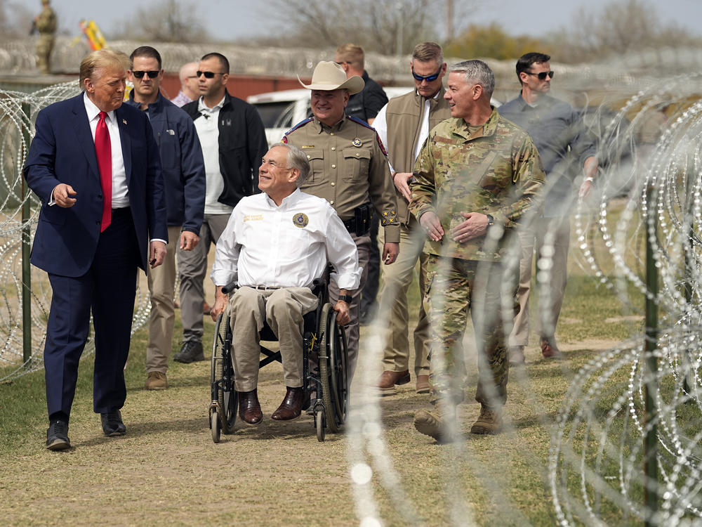 Former President Donald Trump talks with Texas Gov. Greg Abbott during a visit to the border at Eagle Pass, Texas on Feb. 29.