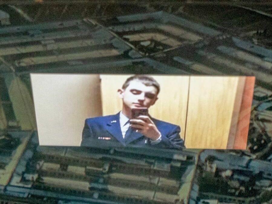 This photo illustration shows national guardsman Jack Teixeira reflected in an image of the Pentagon.