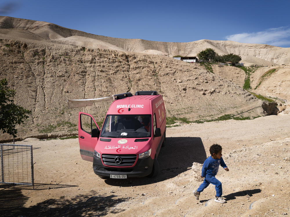 A Bedouin boy passes a mobile medical clinic run by the British charity Medical Aid for Palestinians.