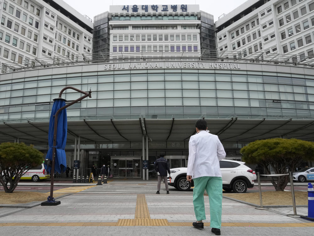 A medical worker walks to enter Seoul National University Hospital in Seoul, South Korea, Thursday, Feb. 29, 2024.