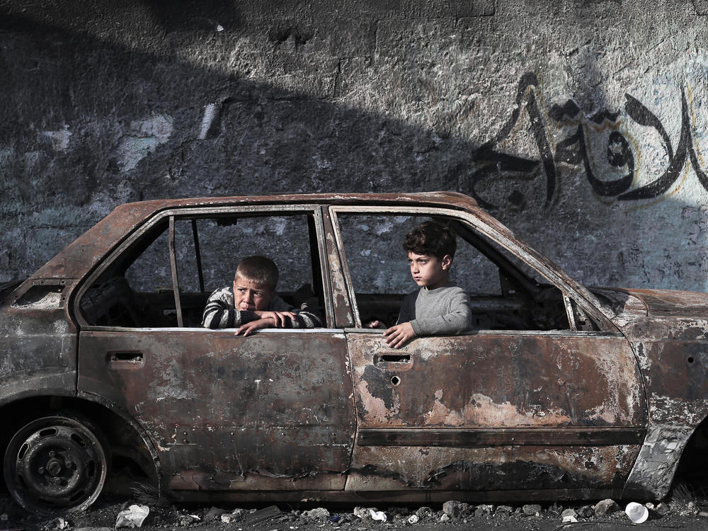 Children sit in a destroyed car in Rafah on Wednesday, Feb. 28.