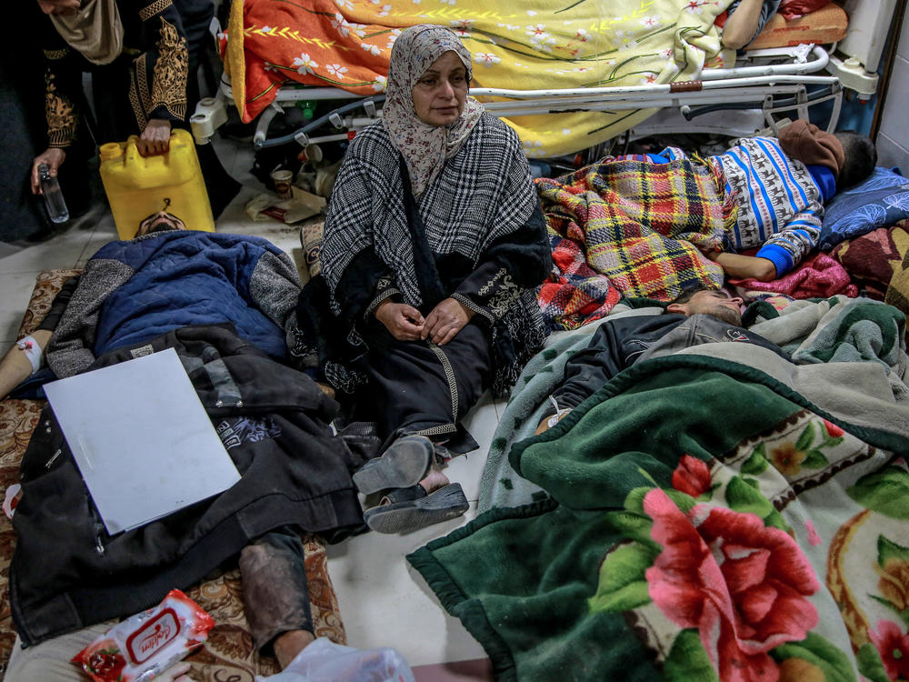 At Al-Shifa hospital in Gaza City, a woman sits among people who were injured when they rushed toward aid trucks in Gaza City on Thursday, Feb. 29.