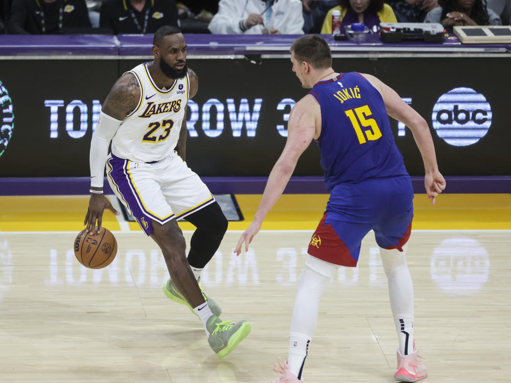 Los Angeles Lakers forward LeBron James (23) dribbles the ball as Denver Nuggets center Nikola Jokic (15) defends during the second half of an NBA basketball game Saturday, March 2, 2024, in Los Angeles.