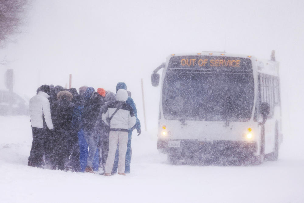A group waits at a bus stop for an 'out of service' bus pull up as a blizzard hits Mammoth Lakes in the Eastern Sierra Nevadas of California, on Saturday.