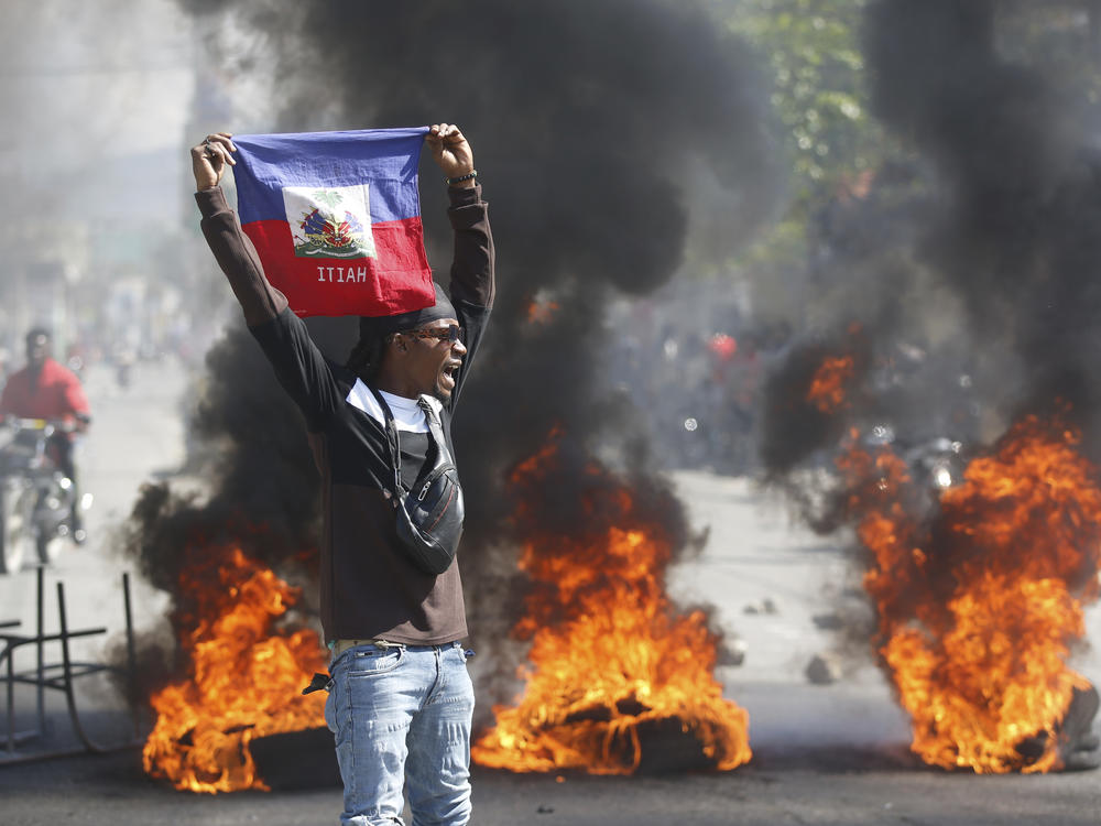 A demonstrator holds up a Haitian flag during protests demanding the resignation of Prime Minister Ariel Henry in Port-au-Prince, Haiti, on Friday.