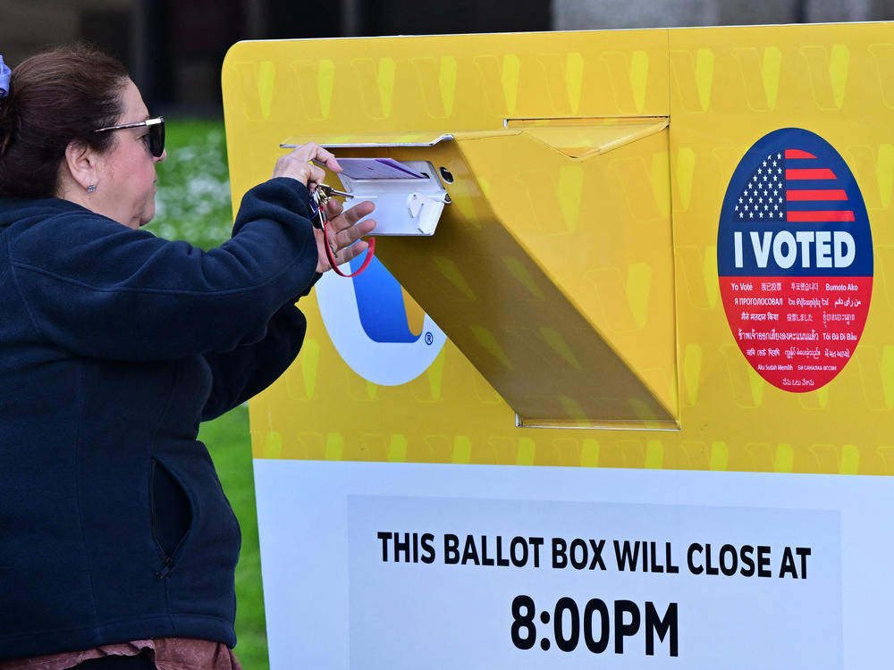 A woman drops her ballot into a ballot box on Monday at the Los Angeles County Registrar in Norwalk, Calif.