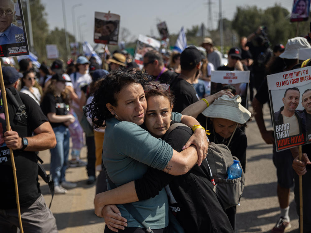 Meirav Leshem Gonen (left), whose daughter Romi is being held hostage in Gaza, embraces Sharon Alony Cunio, who was kidnapped and released from captivity along with her two children and whose husband, David, remains hostage, as the march to Jerusalem passes Kibbutz Sa'ad in southern Israel on Feb. 28.