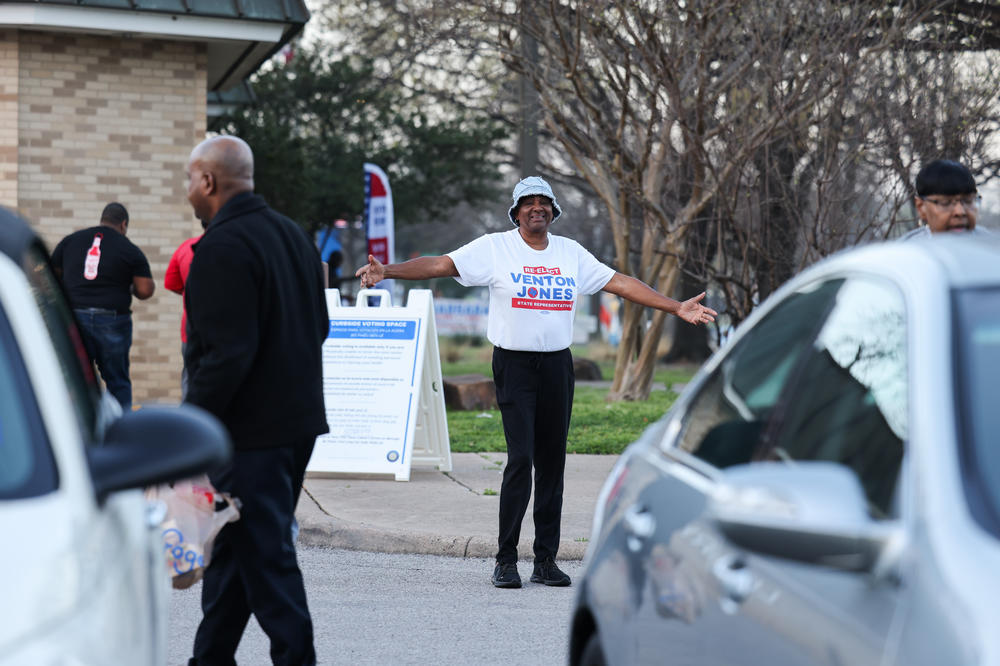 Nethel Jackson greets voters near a polling location at Martin Luther King Public Library in Dallas.