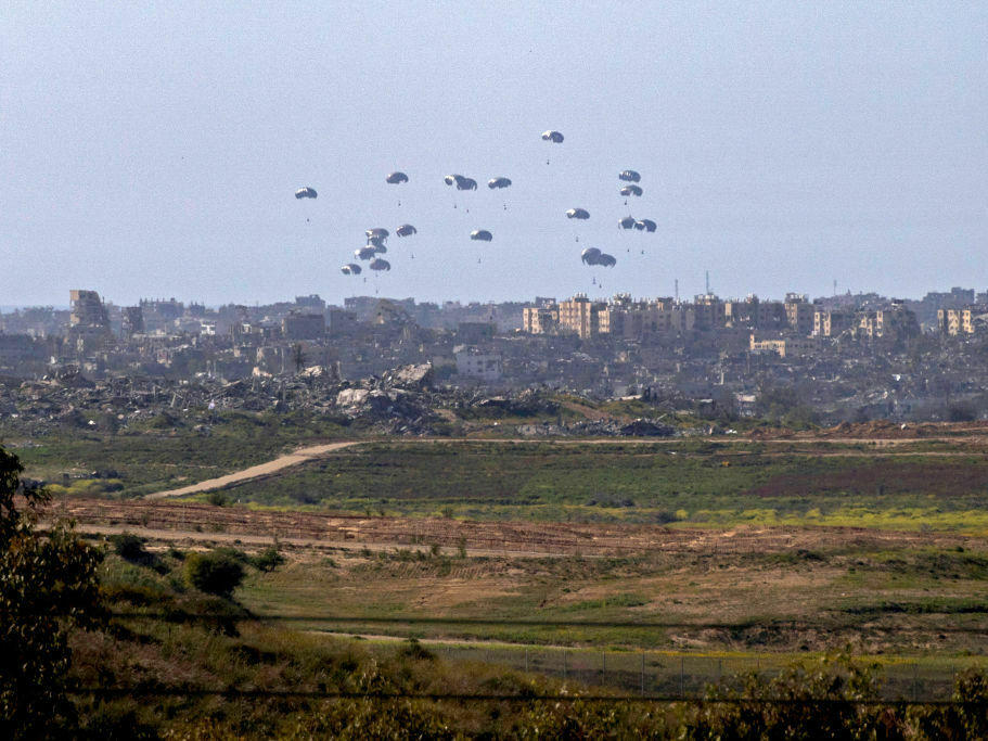 A general view taken from the Israeli side of the border shows aid parcels being airdropped over the northern Gaza Strip on Tuesday. Belgium sent a military transport plane Monday to join an international operation to airdrop aid into Gaza also involving the United States, France and Jordan, officials said.