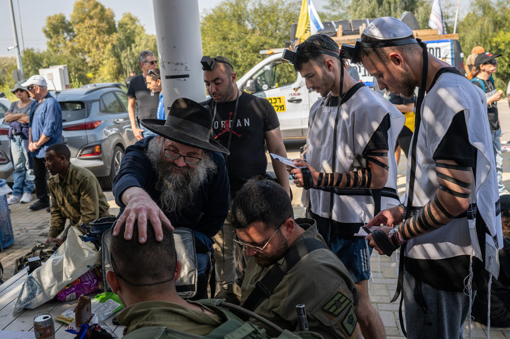People attending the march to Jerusalem and Israeli soldiers accompanying them pray during a break at a gas station near Kibbutz Sa'ad on Feb. 28.