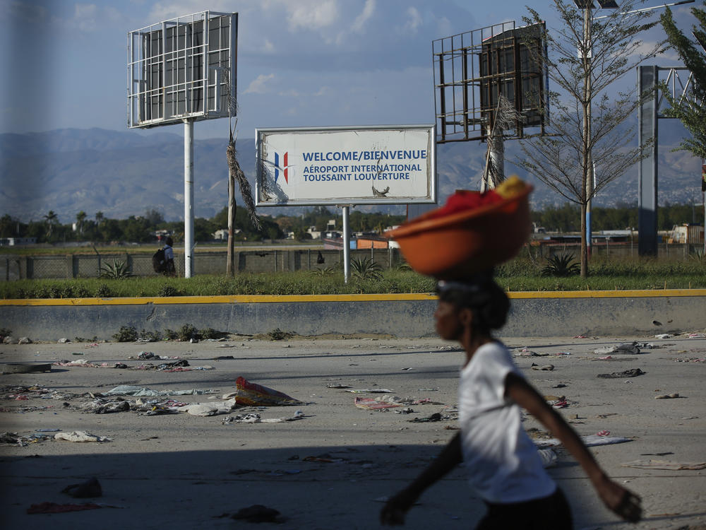 A pedestrian walks past the international airport in Port-au-Prince, Haiti, Monday. Gang members exchanged gunfire with police and soldiers around the airport in the latest of a series of attacks on government sites.