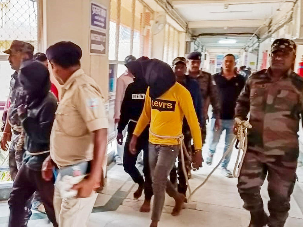 Police escort men accused of allegedly raping a tourist to a district court in Dumka, in India's Jharkhand state, on March 4. The attack took place on March 1; the woman posted a video describing what happened on social media.