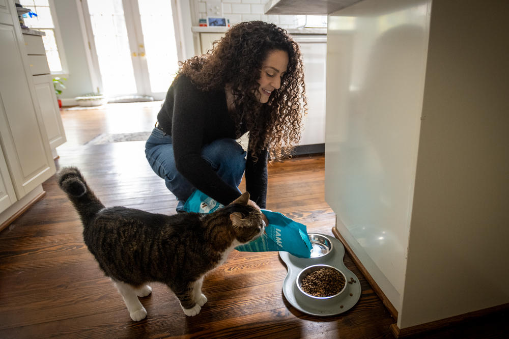 Karen Seagraves feeds her cat, Little Buddy, in her home in Charlotte, N.C.