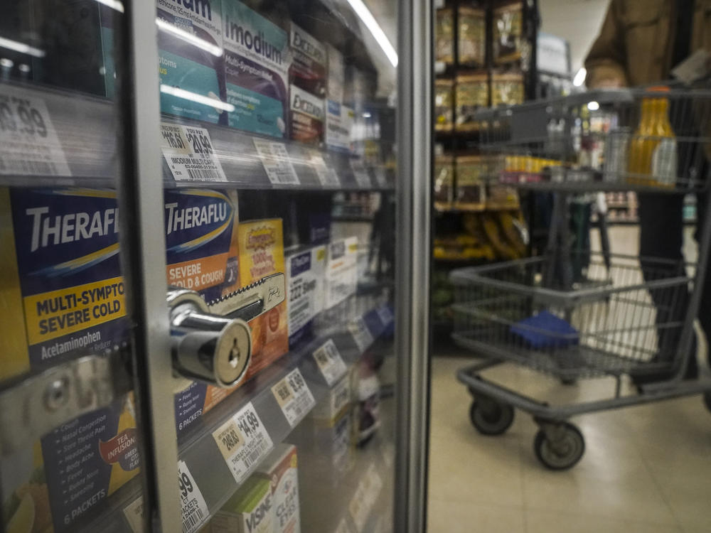 Medications are locked in a glass cabinet at a supermarket.