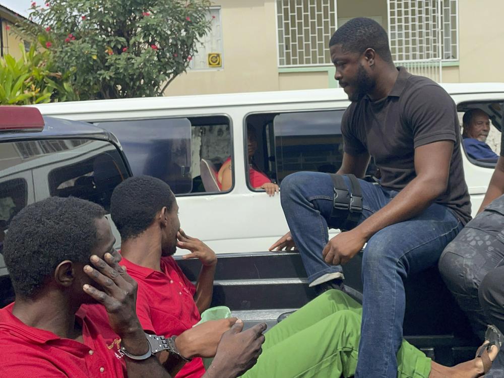 Police transport escaped prisoners Atiba Stanislaus (far left) and Trevon Robertson in Kingstown, St. Vincent and the Grenadines, on Monday. The men had escaped from a police holding cell in Grenada on Feb. 18 and are suspected of hijacking a catamaran while Ralph Hendry and Kathy Brandel, who disappeared, were aboard.