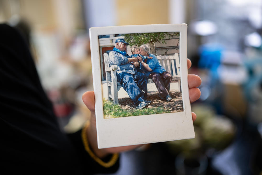 Carmit Palty Katzir holds a photo of her parents Rami and Hana Katzir with one of her children, at her home in Haifa, Israel, Feb. 18. Her father was killed on Oct. 7 and her mother was taken hostage and released in November.